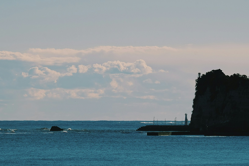 青い海の奥に灯台が見える風景。千葉・勝浦